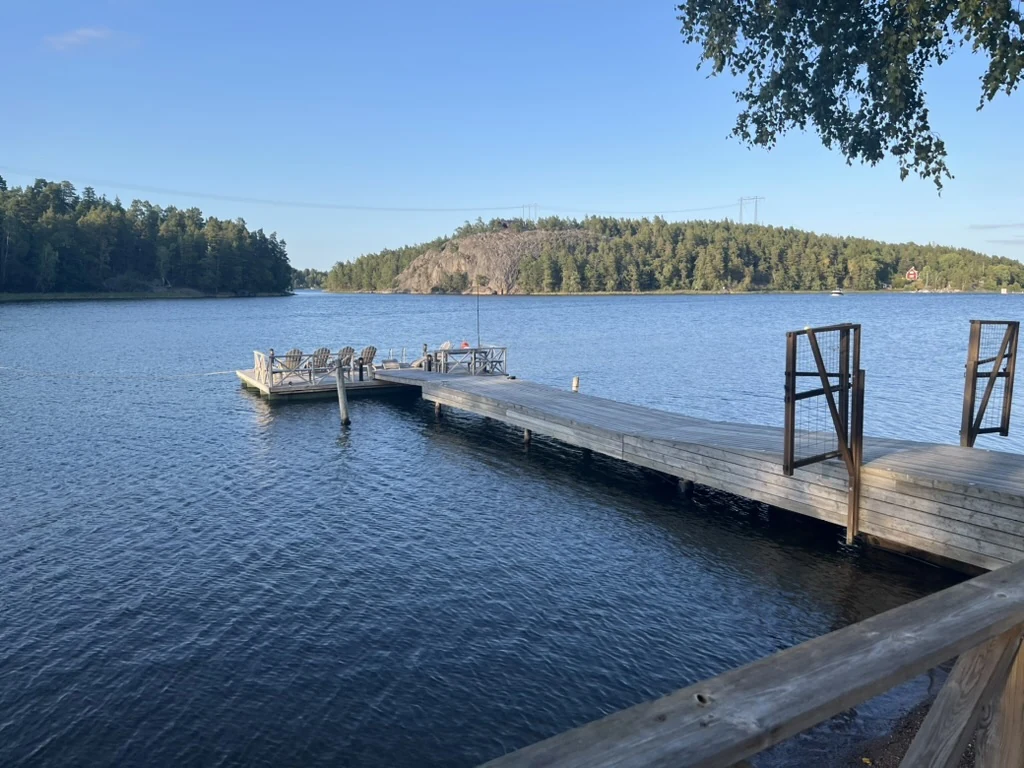 Home A wooden jetty extending into a lake surrounded by Nordic woodland